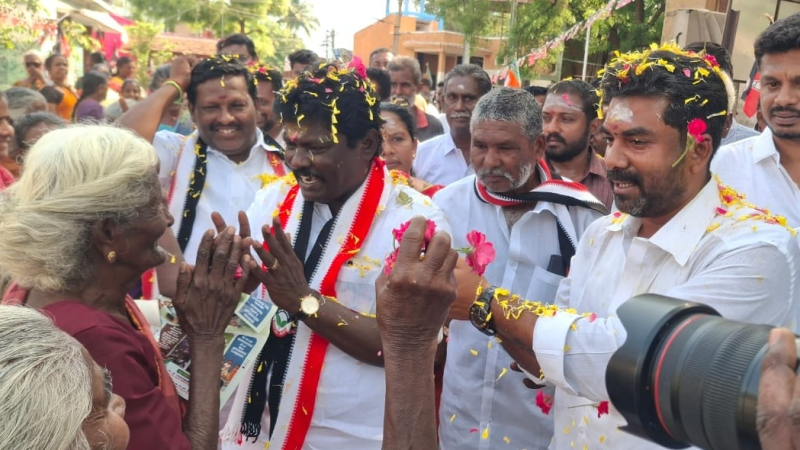 அ.தி.மு.க.வேட்பாளர் கி.மாணிக்கத்தை வெற்றி உறுதி என்று மலர் தூவி வாழ்த்திய மூதாட்டி